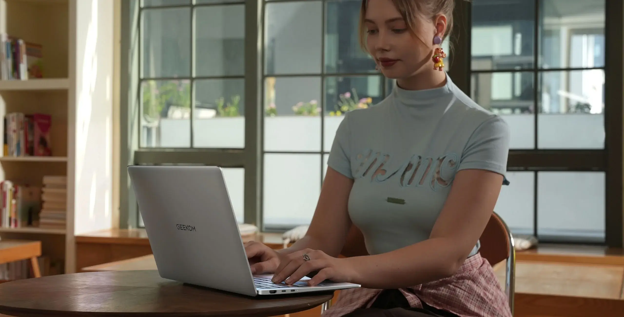 In einer gemütlichen Umgebung benutzt eine Frau einen Geekbook-Laptop.