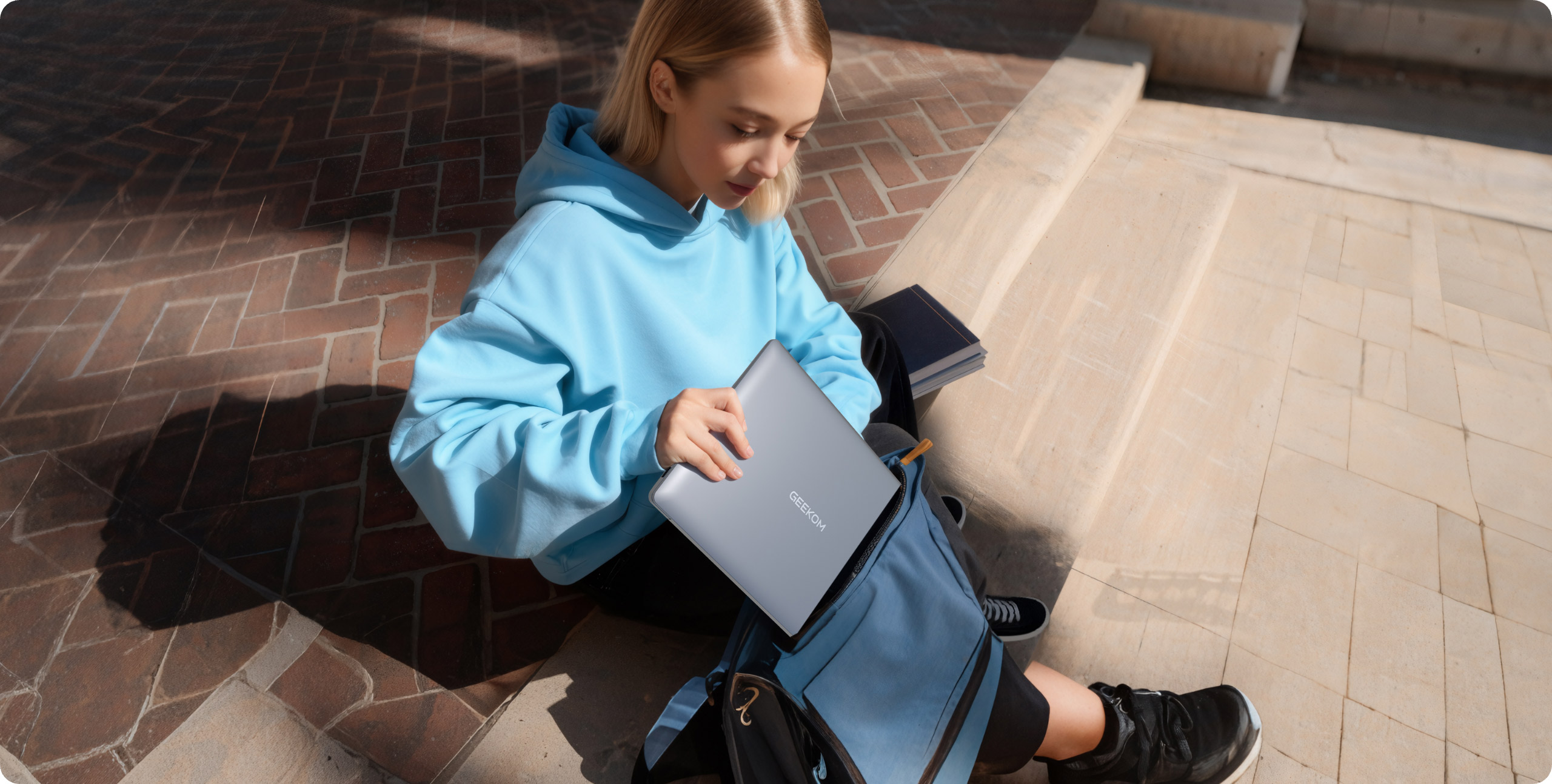 Die Studentin saß auf den Steinstufen und holte ihren Geekbook-Laptop aus ihrer Tasche.